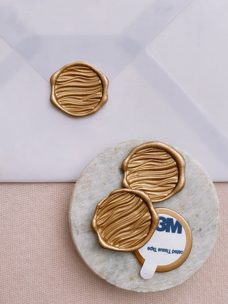 3D waves wax seals in gold with 3m sticker on small gray stone dish