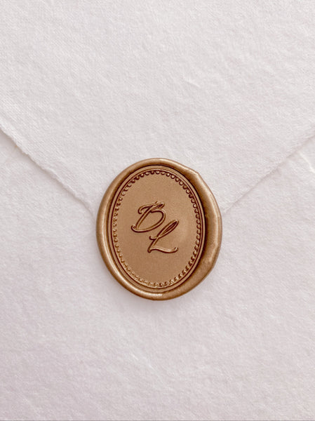 Calligraphy script monogram oval gold wax seal with a border design