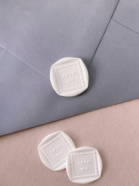Open Me wax seals in off-white on dusty blue envelope