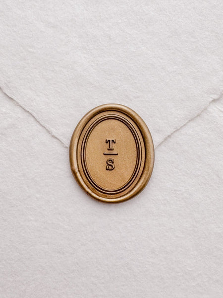 custom initials gold wax seal with an oval double border design
