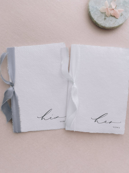 white handmade paper His and Her vow books tied in gray and white silk ribbon