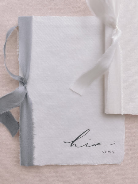 white handmade paper His and Her vow books tied in gray and white silk ribbon