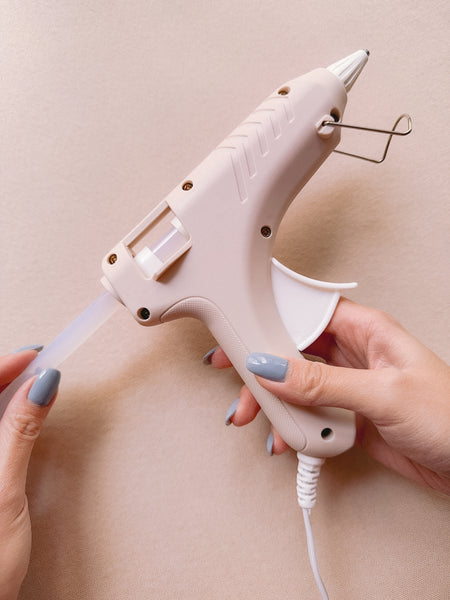 inserting a clear glue stick into a beige sealing wax gun