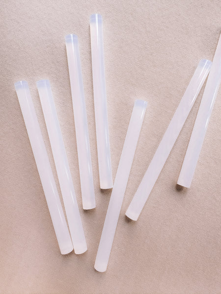 clear glue sticks on a nude backdrop