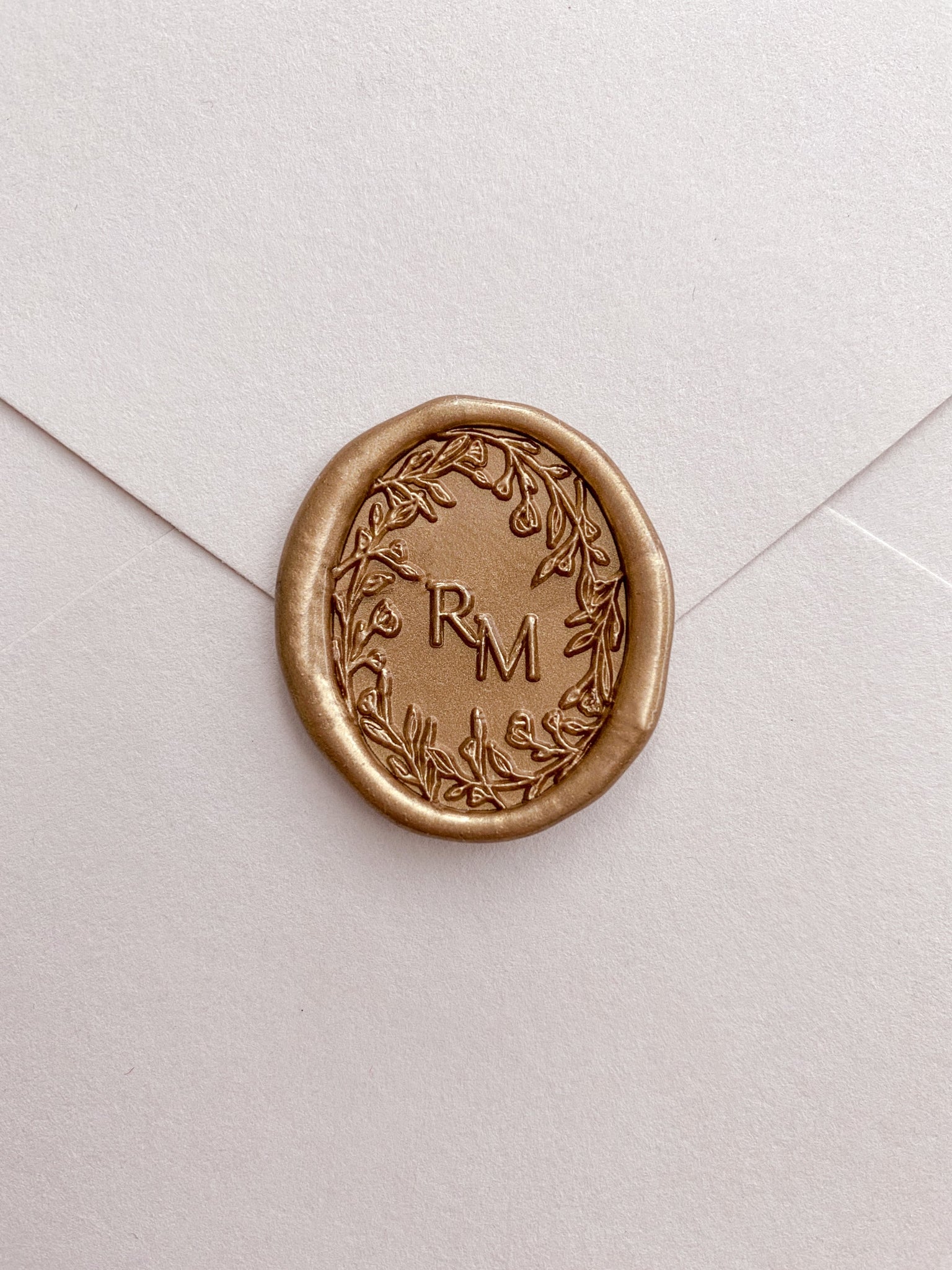 Oval floral crown monogram gold custom wax seal on beige paper envelope 