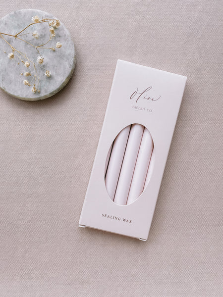 a box of 5 glue gun sealing wax sticks in ivory nude color styled with small gray stone dish and dried flowers