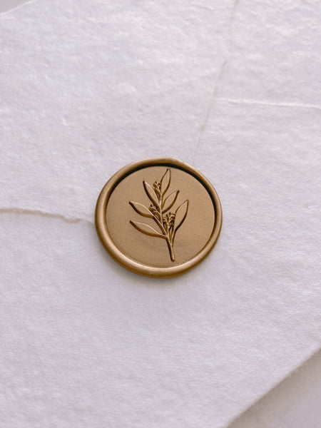 Leaf branch wax seal in gold on beige handmade paper envelope