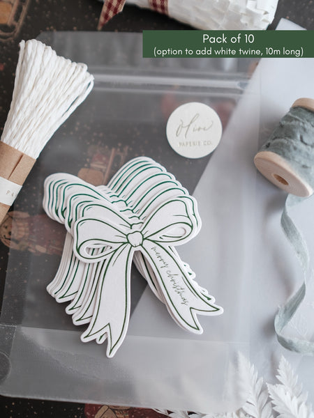 Stack of green Merry Christmas gift tags with white twine