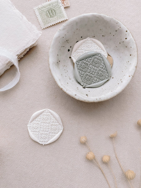 Moroccan tile pattern gold square wax seals in off white and sage green styled with place cards tied with silk white ribbon