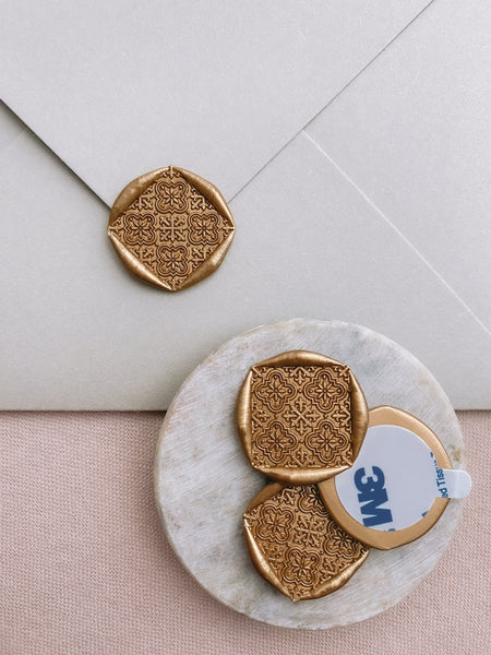 Nora moroccan tile wax seals in gold with 3m sticker on small gray stone dish
