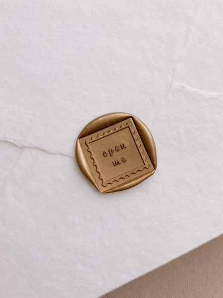Open me wax seal in gold on beige handmade paper envelope
