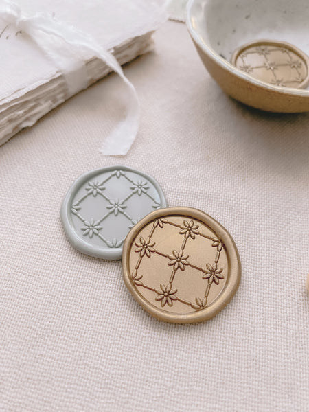 Daisies symmetrical pattern gold wax seals in light gold and sage green styled with handmade paper place cards tied with white silk ribbon