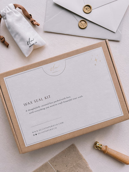 flat lay showcasing the gift packaging of our wax seal kit, styled with envelopes, wax seals, and wax stamp