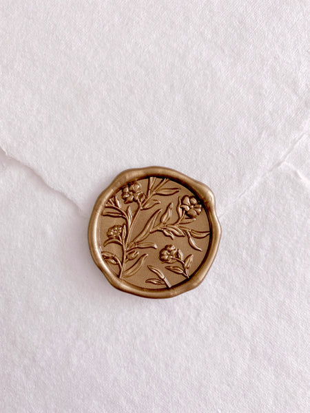 3D flower design gold wax seal on a white envelope
