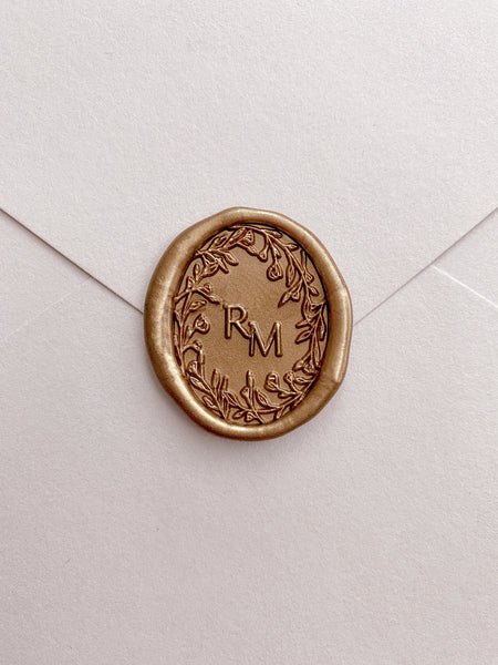 floral wreath custom initials gold oval wax seal on a beige envelope