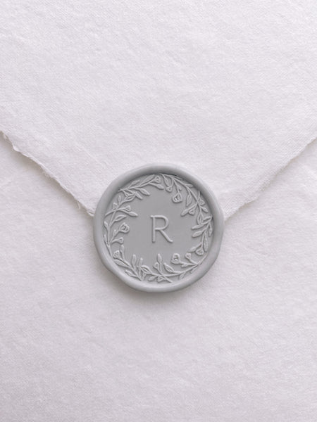 Floral crown single initial wax seal in light gray on handmade paper envelope_front angle