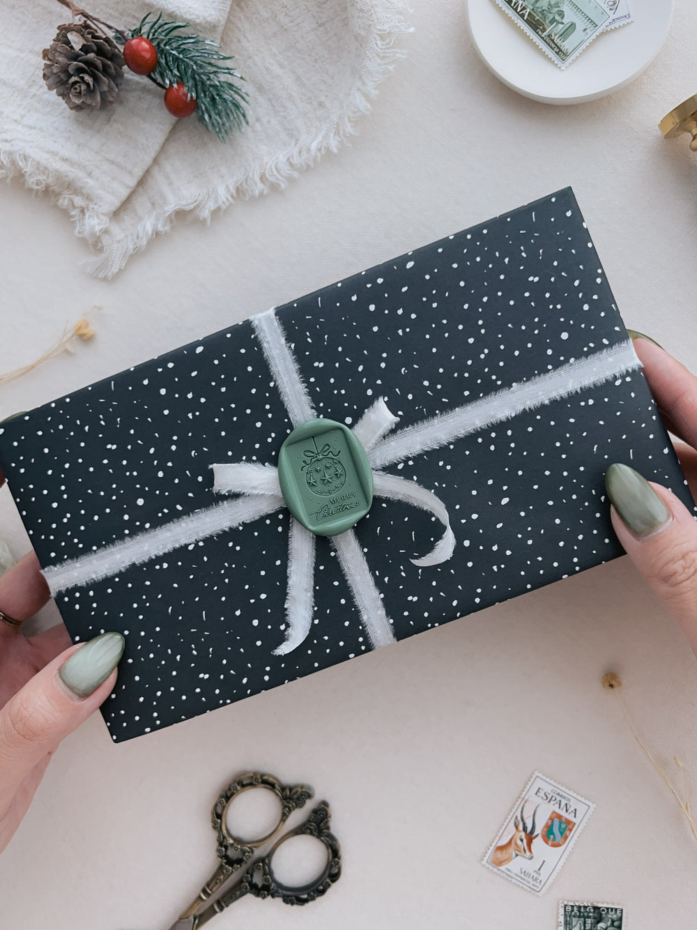 Green festive ornament Merry Christmas rectangular wax seal on a wrapped gift