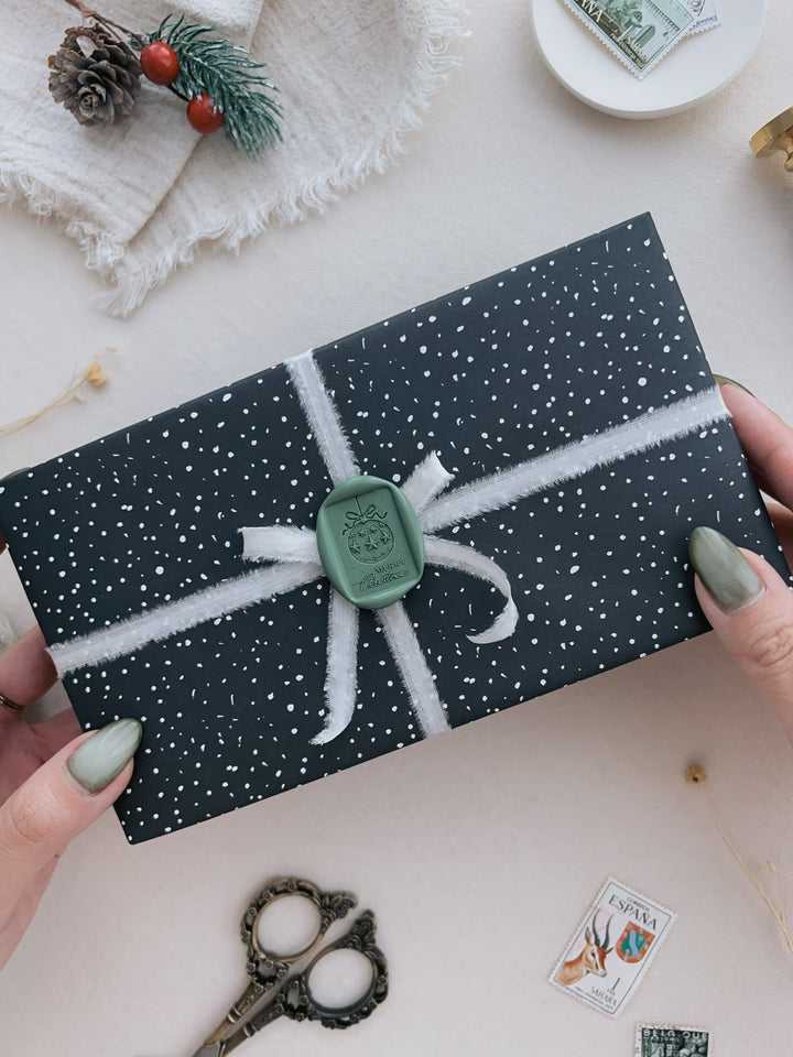 Green festive ornament Merry Christmas rectangular wax seal on a wrapped gift