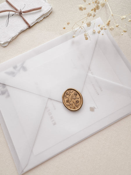 Floral pattern oval gold wax seal with 3D engraving details on a vellum envelope