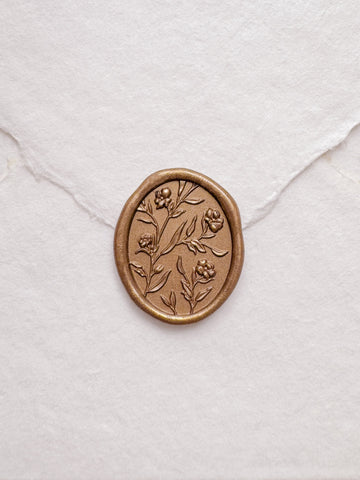 Floral pattern oval gold wax seal on a white handmade paper envelope