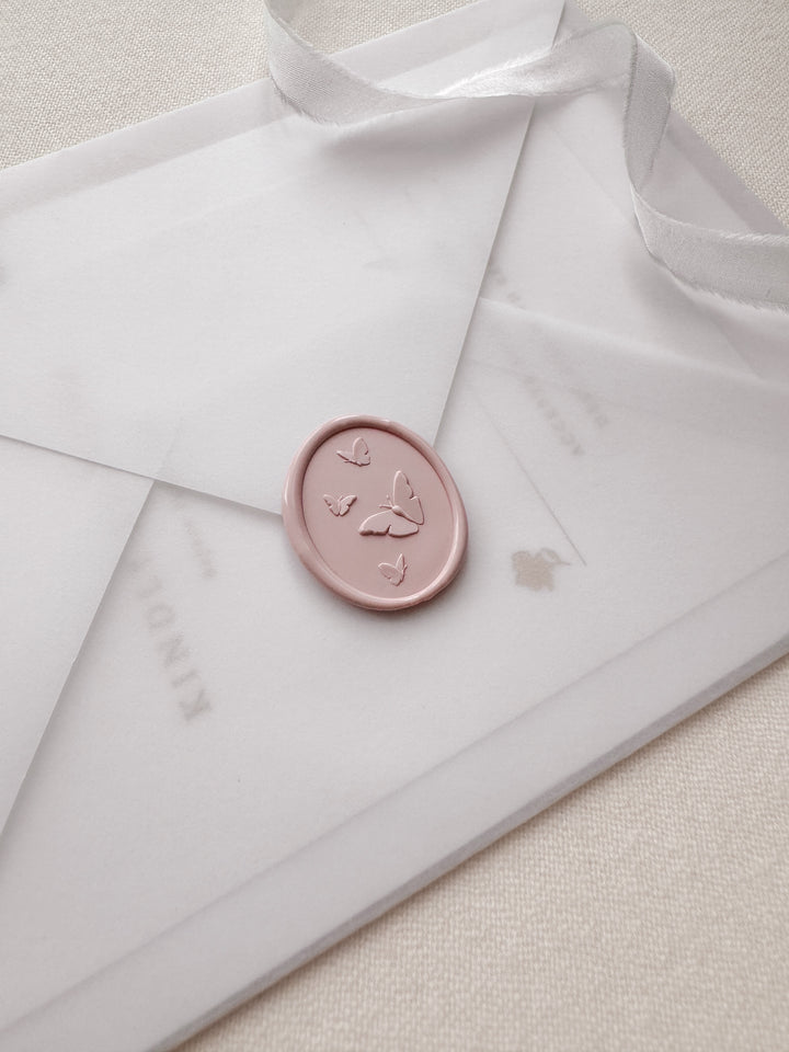Light pink 3D butterflies oval wax seal on a translucent vellum wedding invitation envelope