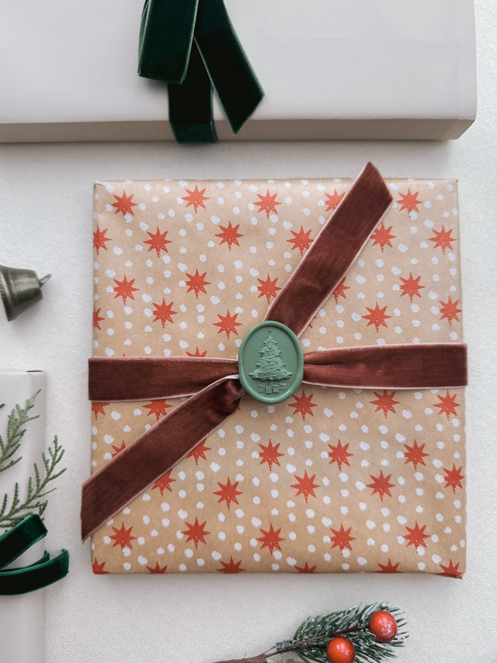 green 3D Christmas tree wax seal on festive gift wrap