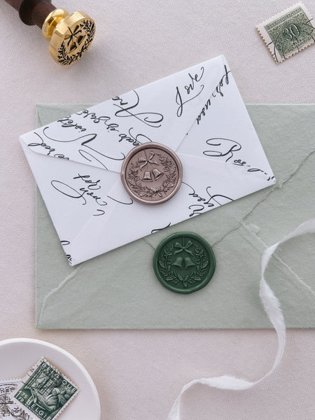 dark green and light bronze festive wreath Christmas wax seals with 3D engraving on sage green and white envelopes