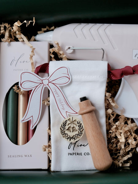Christmas wax seal kit that includes a wax stamp head, wooden handle, festive sealing wax sticks and a glue gun