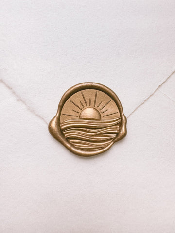 Sun and ocean waves gold wax seal with 3D engravings on a white handmade paper envelope