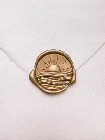Sun and ocean waves gold wax seal with 3D engravings on a white handmade paper envelope