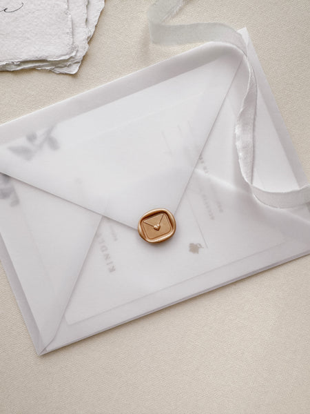 Mini peachy gold colored wax seal featuring a heart sealed envelope design with 3D engravings on a vellum envelope