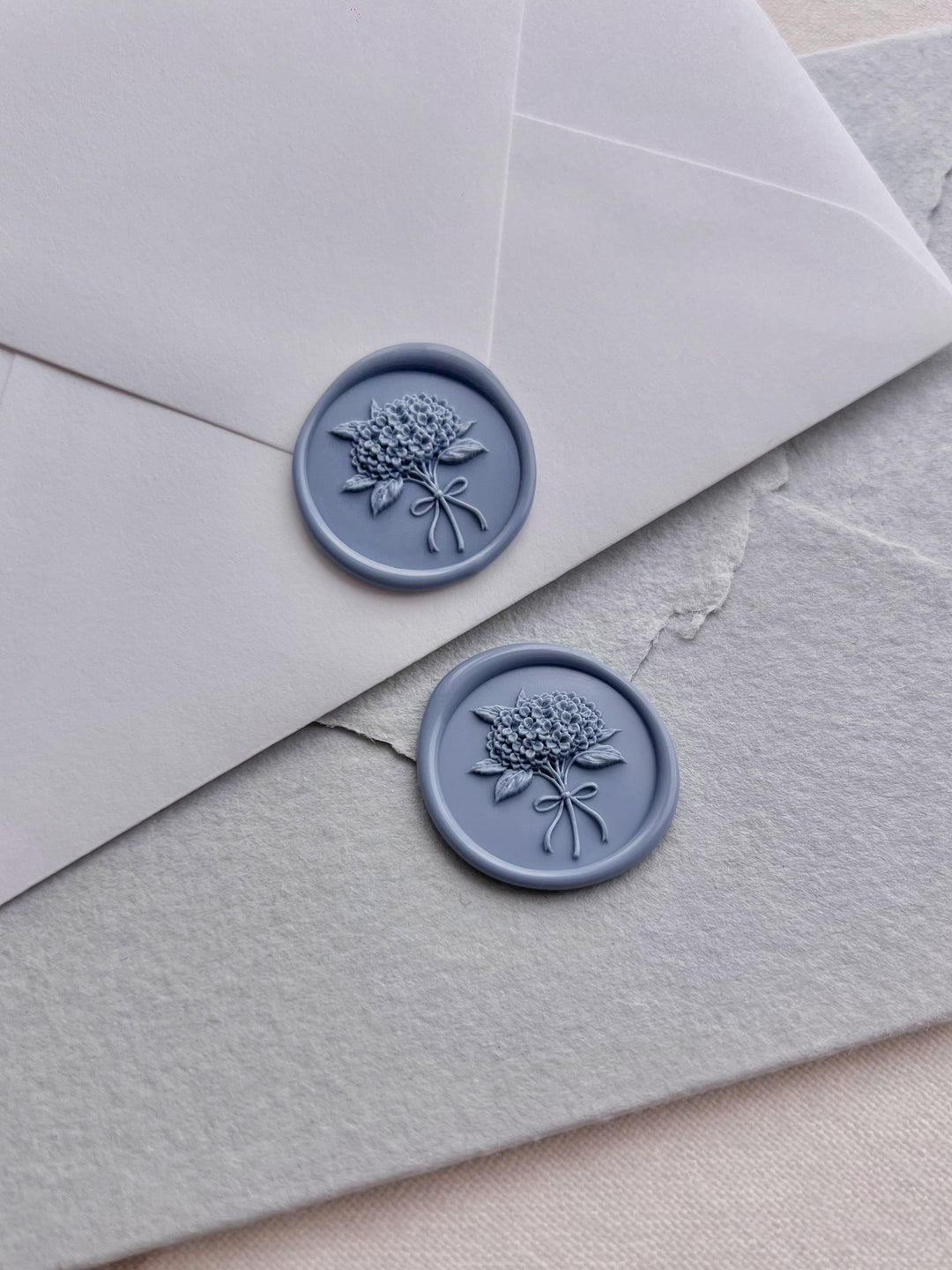 Dusty blue hydrangea bouquet floral wax seals on white and light blue envelopes