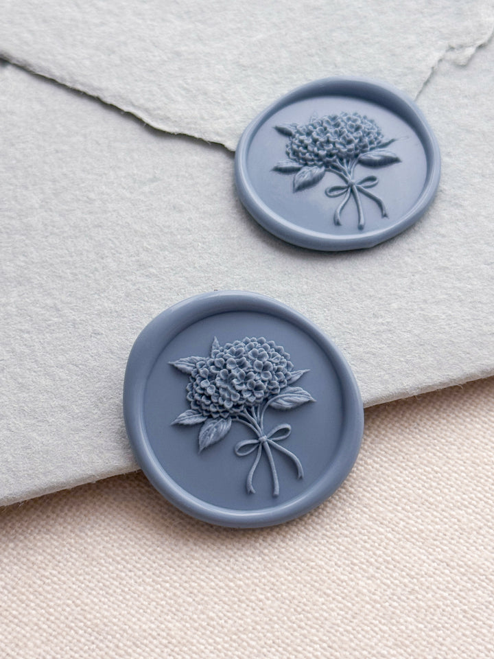 Dusty blue 3D hydrangea bouquet wax seals on a light blue handmade paper envelope