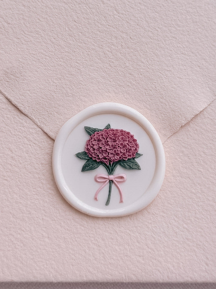 Multi-colored 3D hydrangea bouquet wax seal on a light orange textured envelope