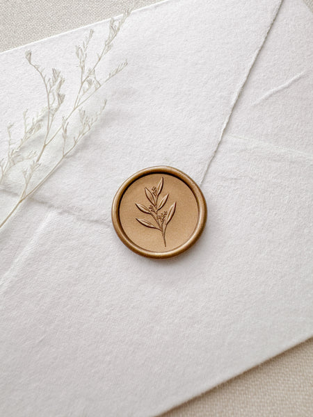 Leaf branch gold wax seal with 3D engraving details on a white handmade paper envelope