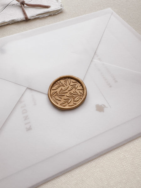 Leaf pattern gold wax seal on a vellum envelope