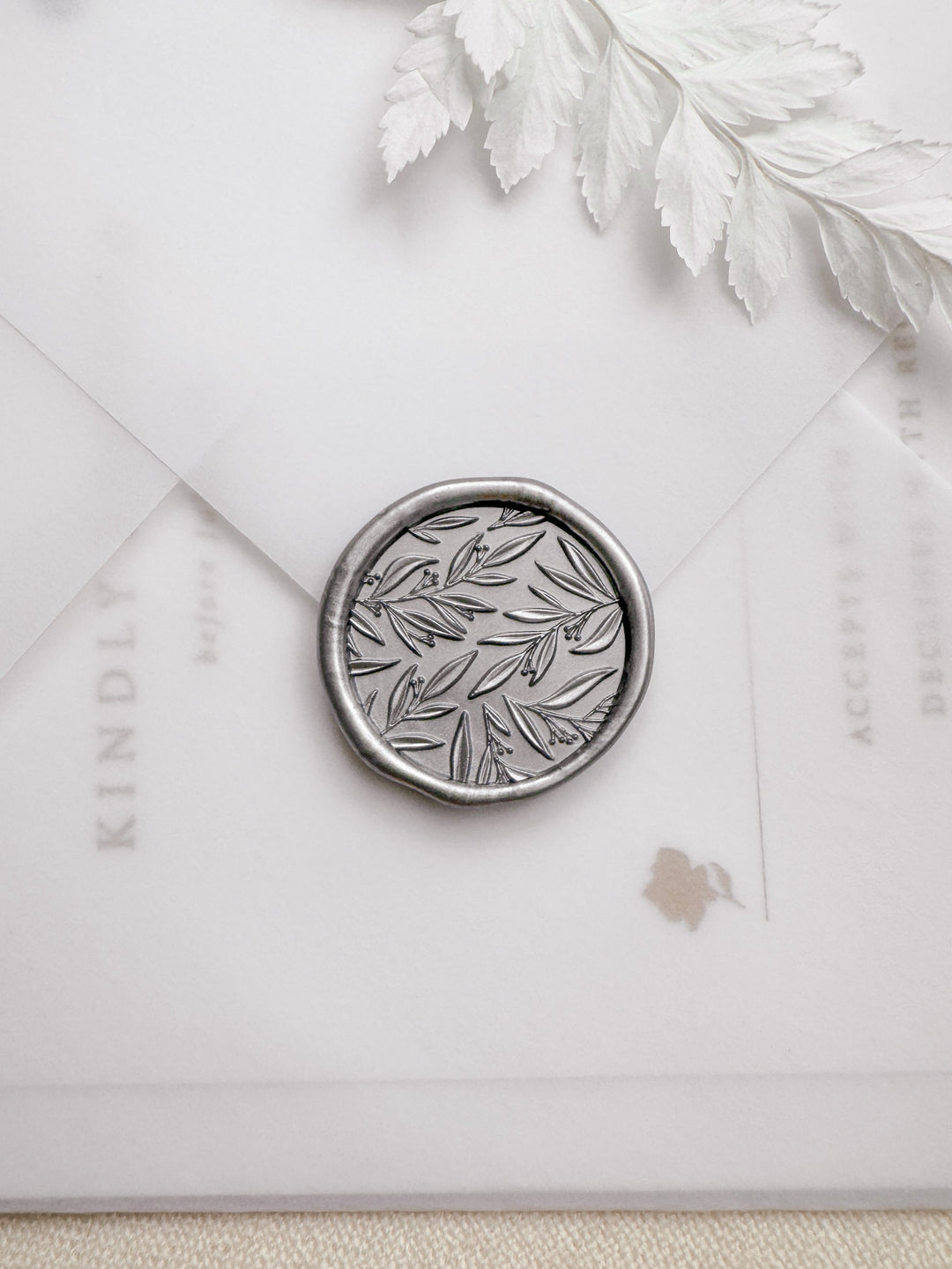 Silver leaf pattern botanical wax seal with 3D engraving details on a vellum envelope