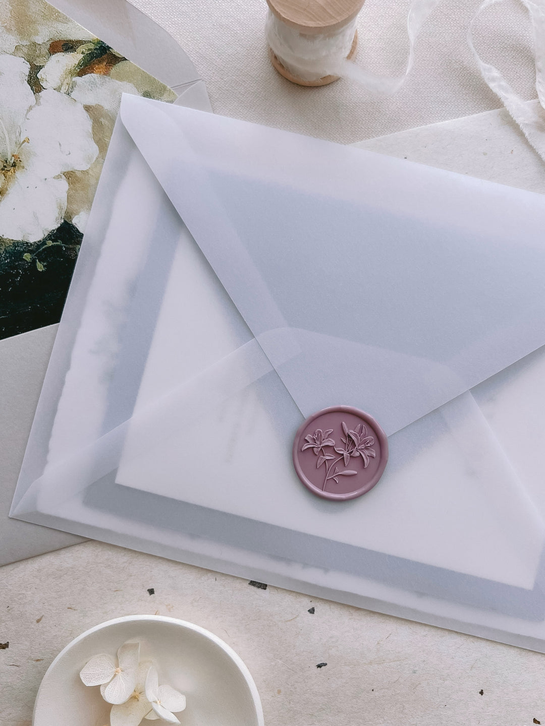 Mauve lilies floral wax seal with 3D engraving on a vellum wedding invitation envelope