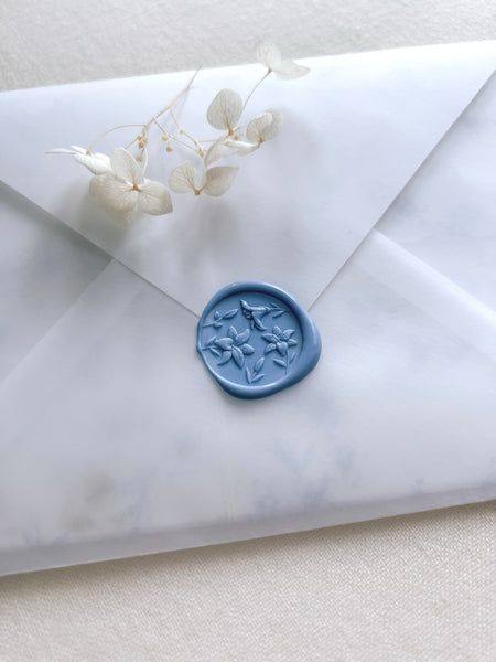 dusty blue 3D lily flower design wax stamp on a vellum wedding invitation envelope