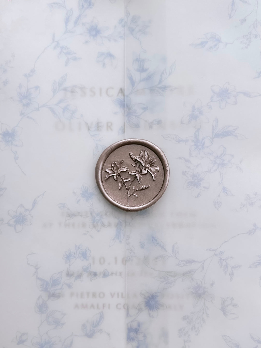 Light bronze 3D lily flowers wax seal on a blue botanical print vellum jacket