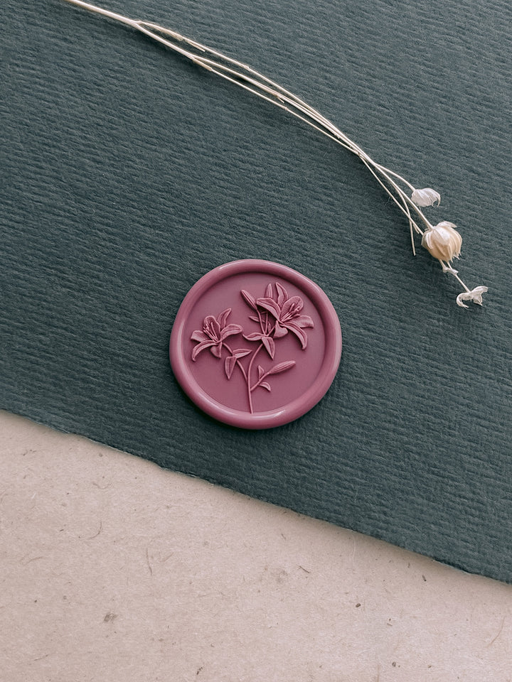 Rose pink 3D lily blossom wax seal on a dark green textured paper 