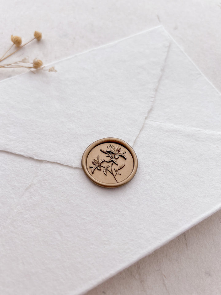 3D lily flower design gold wax seal on a white envelope