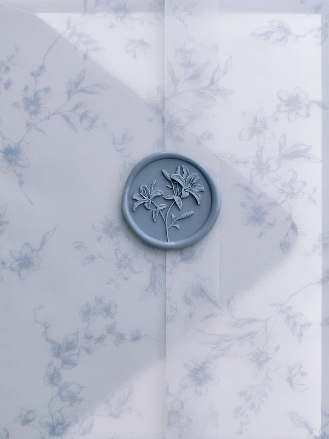 Dusty blue 3D lily wax seal on a blue floral print vellum wrap
