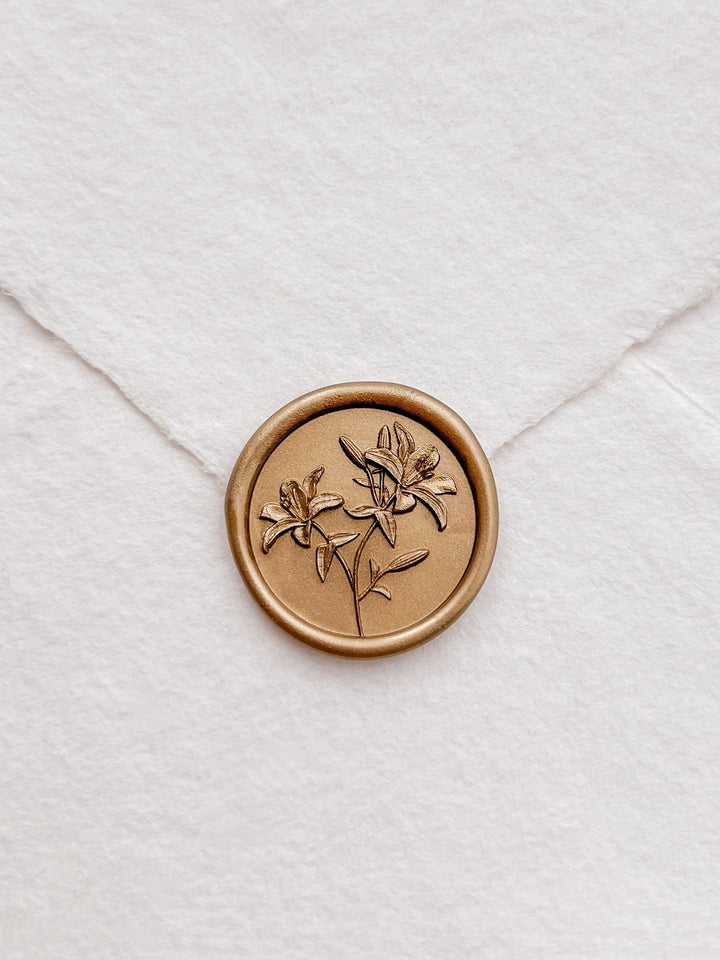 Gold 3D lily flowers wax seal on a white textured handmade paper envelope