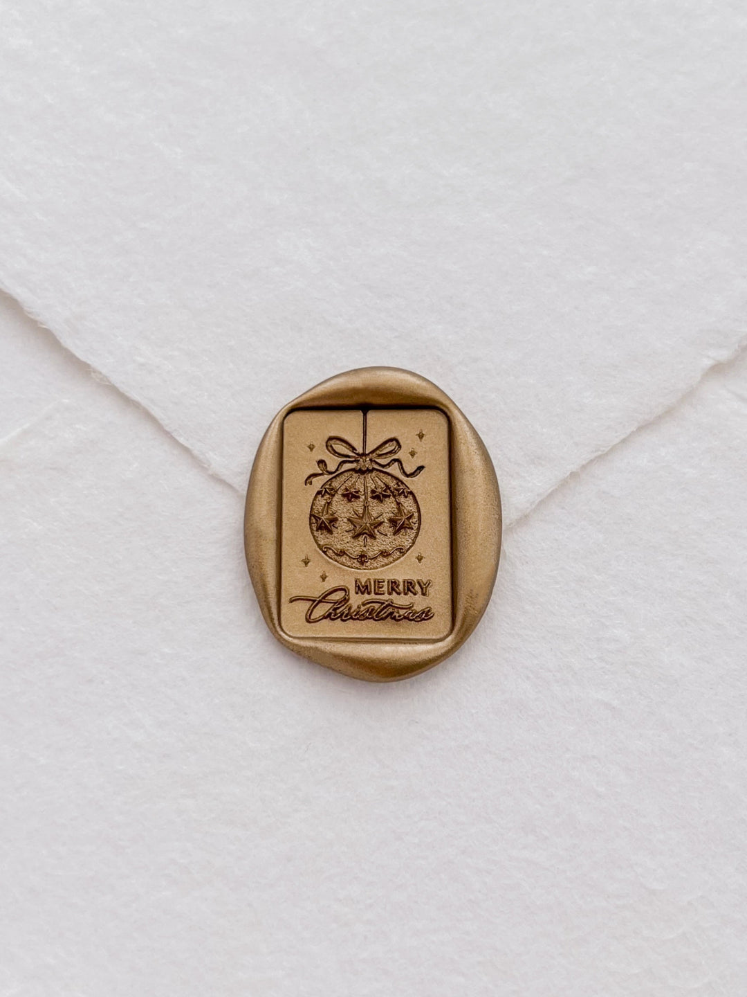 gold Merry Christmas ornament design rectangular wax seal on a white envelope