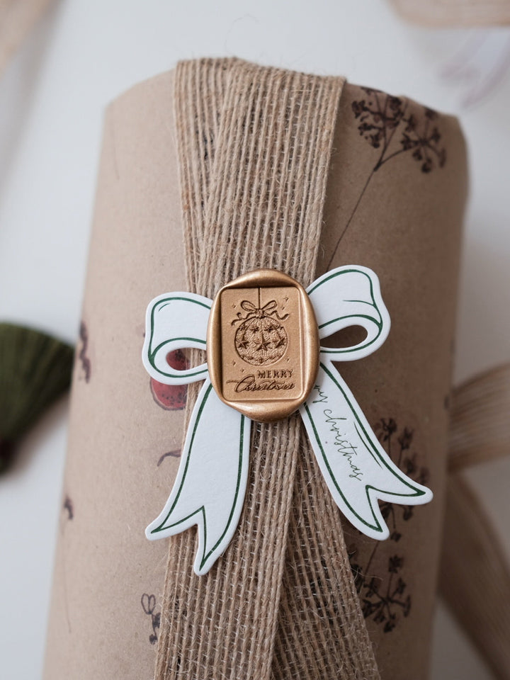 Gold festive ornament Merry Christmas design wax seal on a wrapped Christmas gift