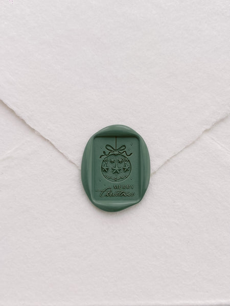 Green festive ornament and Merry Christmas design rectangular wax seal on a white envelope