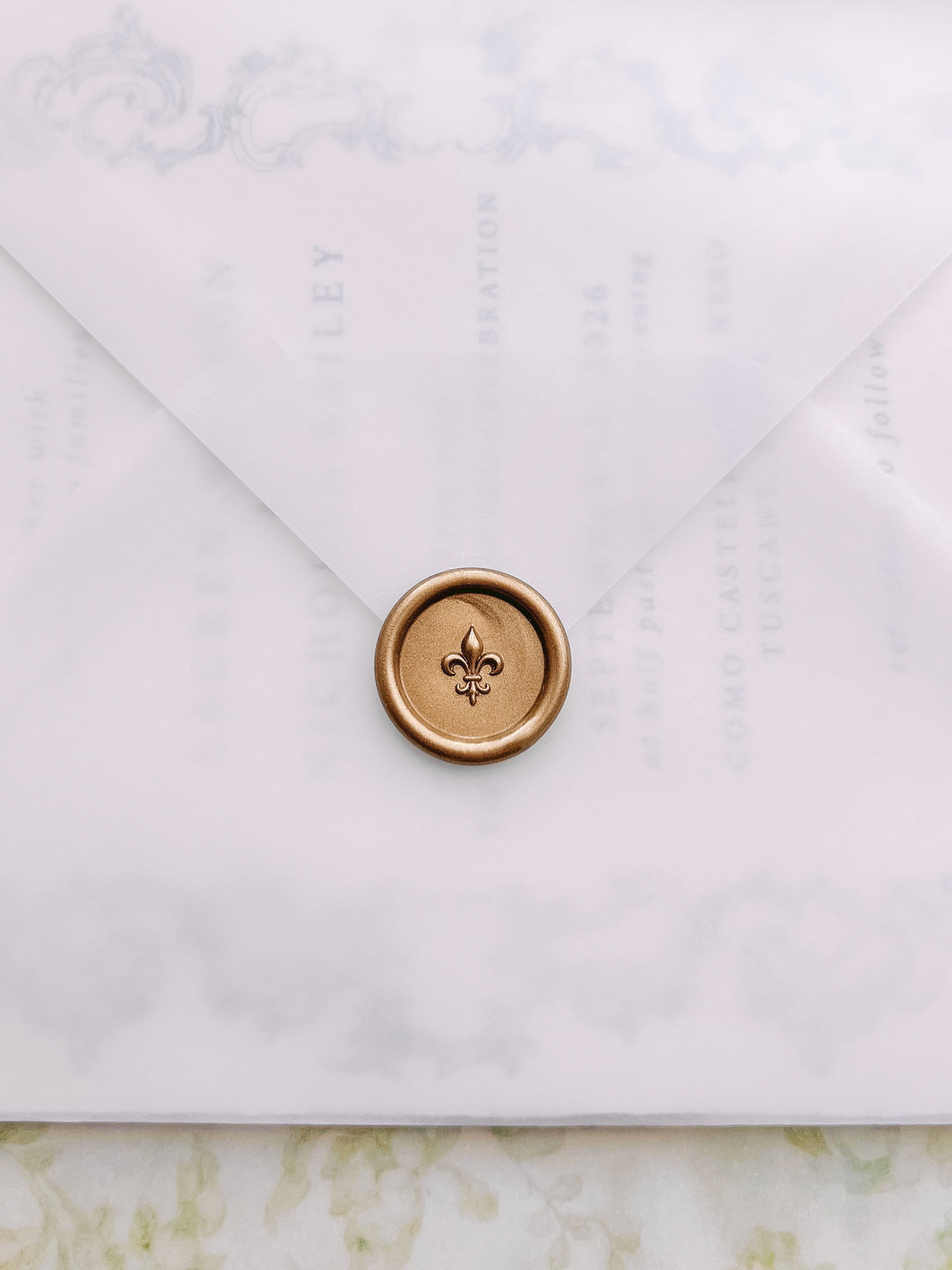 Gold mini 3D fleur de lis wax seal on a vellum wedding inivitation envelope