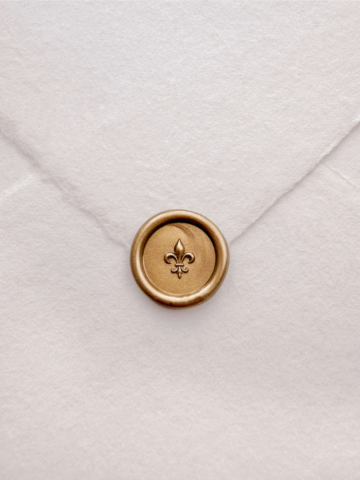 Gold 3D fleur de lis mini wax seal on a white handmade paper envelope