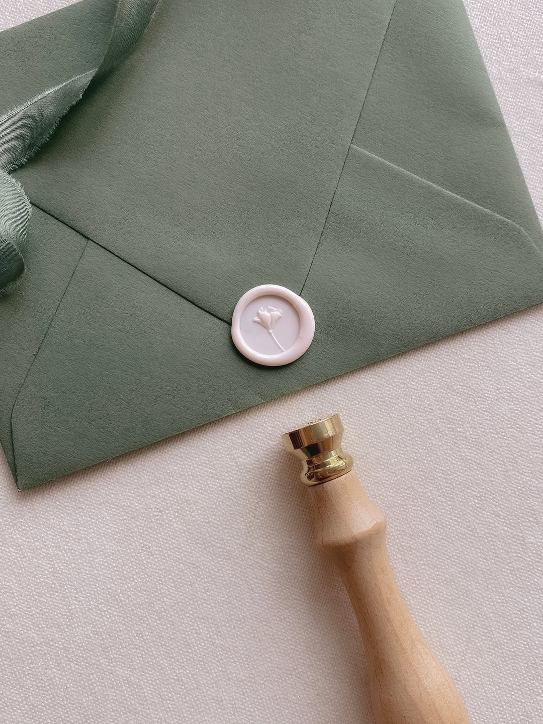 Mini flower wax seal with 3D engraving on olive green paper envelope styled with wax seal stamp